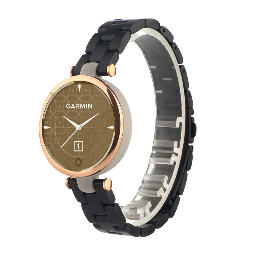 Garmin Lily smartwatch with rose gold case, brown dial, and black silicone bracelet strap shown from side view