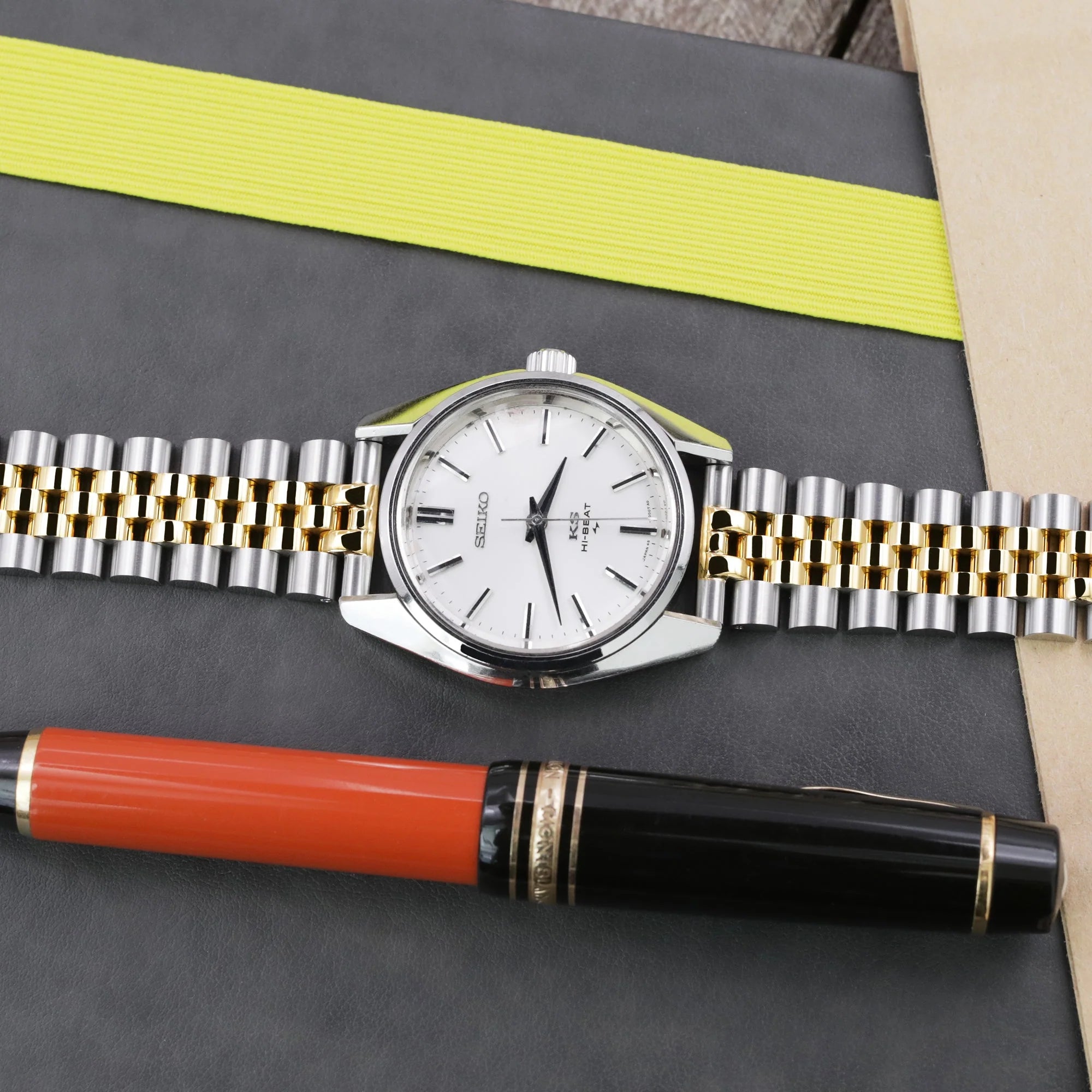 Two-tone stainless steel and gold watch bracelet with quick release Super-Jub II design and V-clasp on dark display board