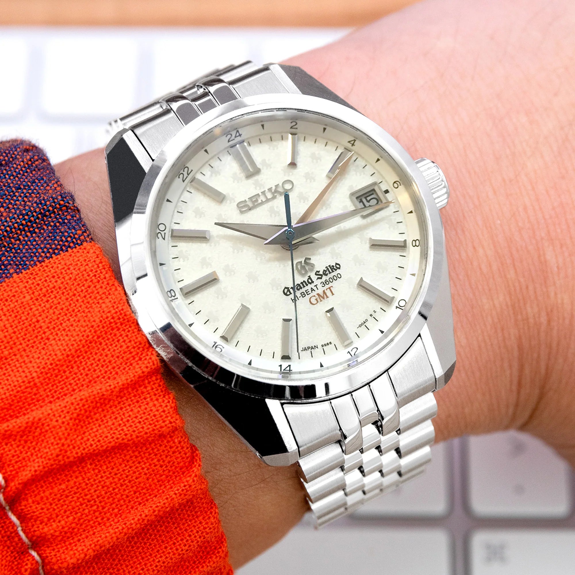 Seiko Grand Seiko SBGJ235 GMT watch with cream dial and stainless steel bracelet on wrist