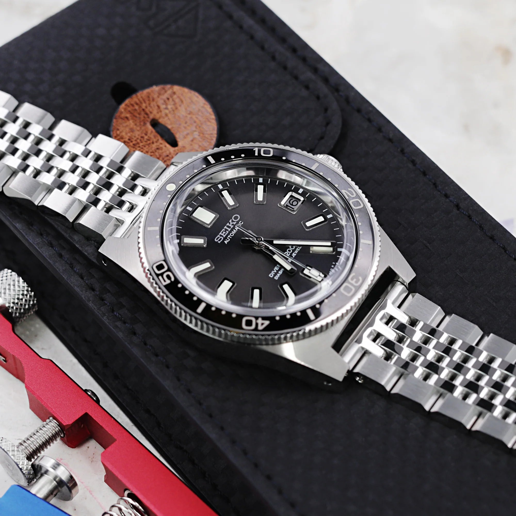 Strapcode Quick Release Asteroid bracelet with V-clasp steel watch band on black leather pouch with tools