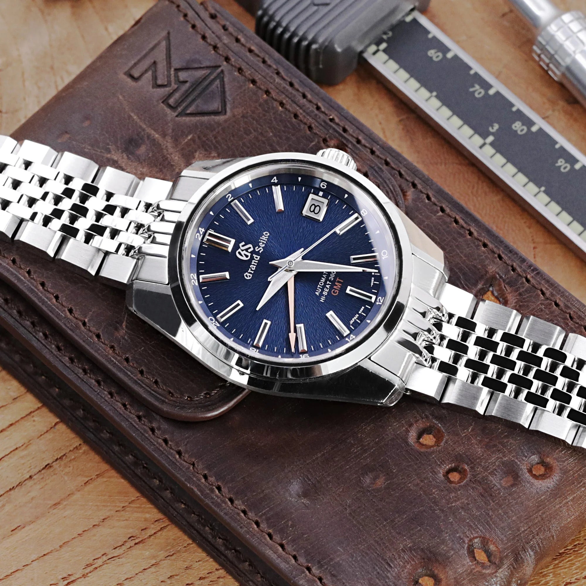 Strapcode Asteroid steel bracelet with solid links on Grand Seiko watch with blue dial and date window