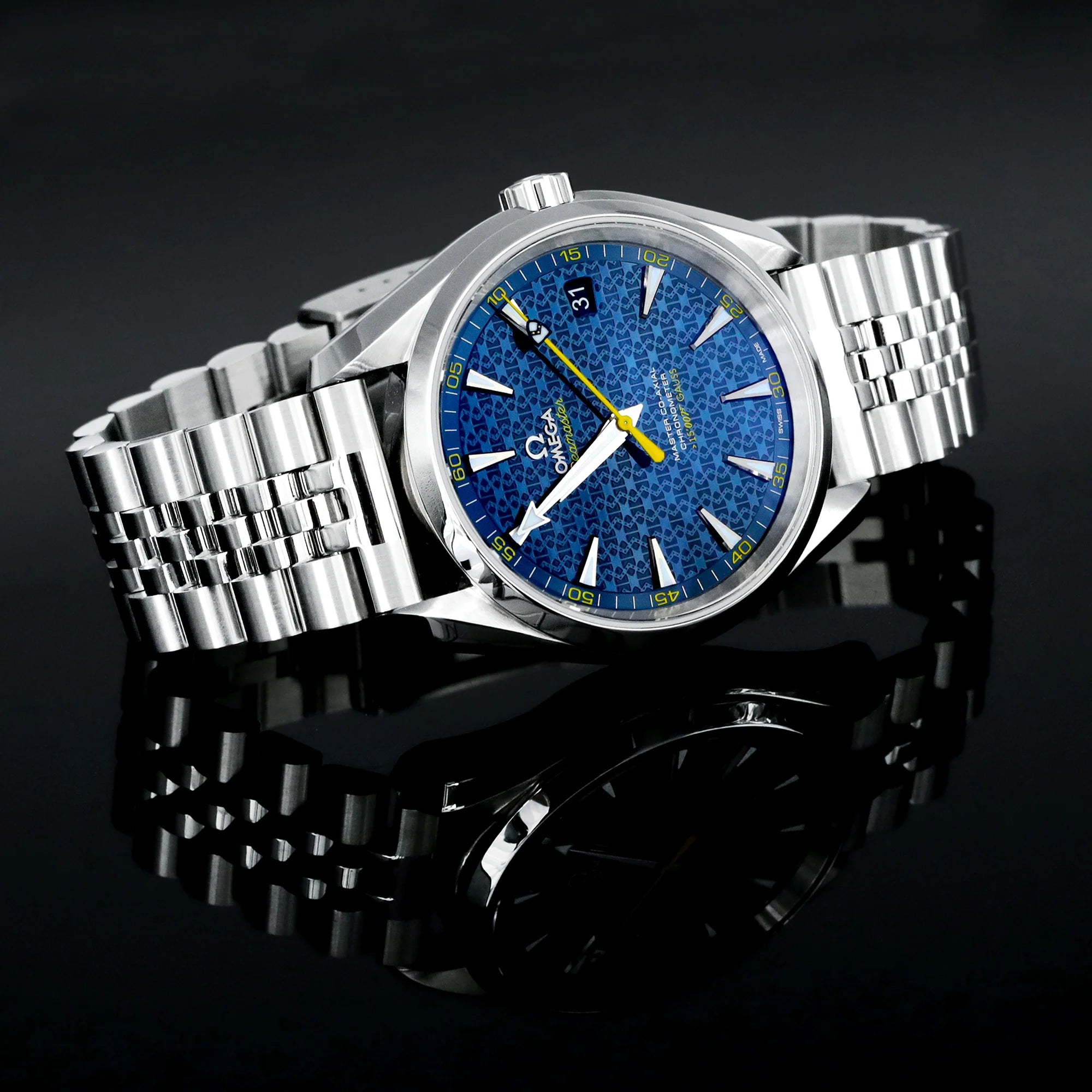 Stainless steel luxury watch with blue dial, yellow hands, and matching steel bracelet on dark background