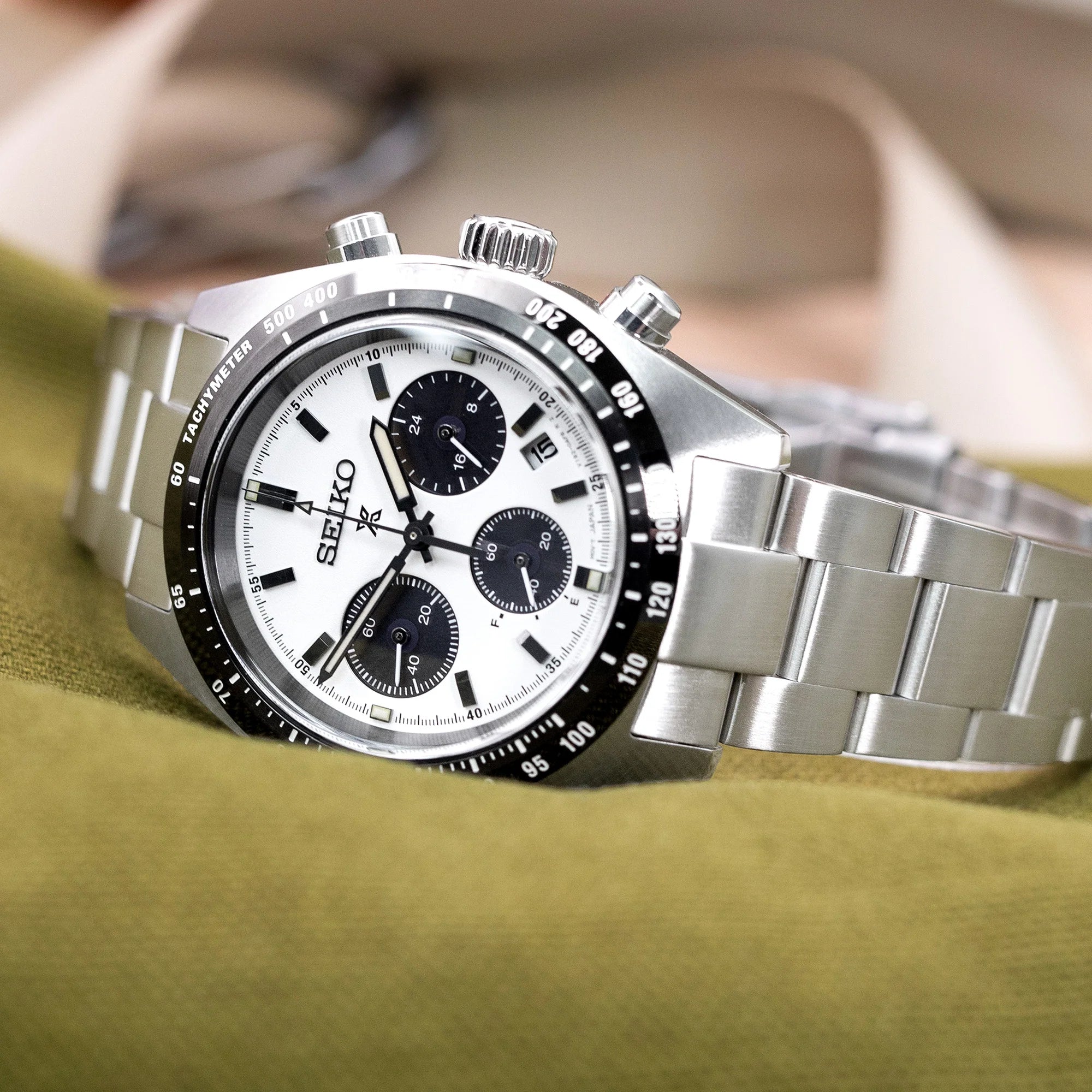 Seiko Speedtimer SSC813 chronograph watch with stainless steel Super-O Boyer bracelet on green fabric background