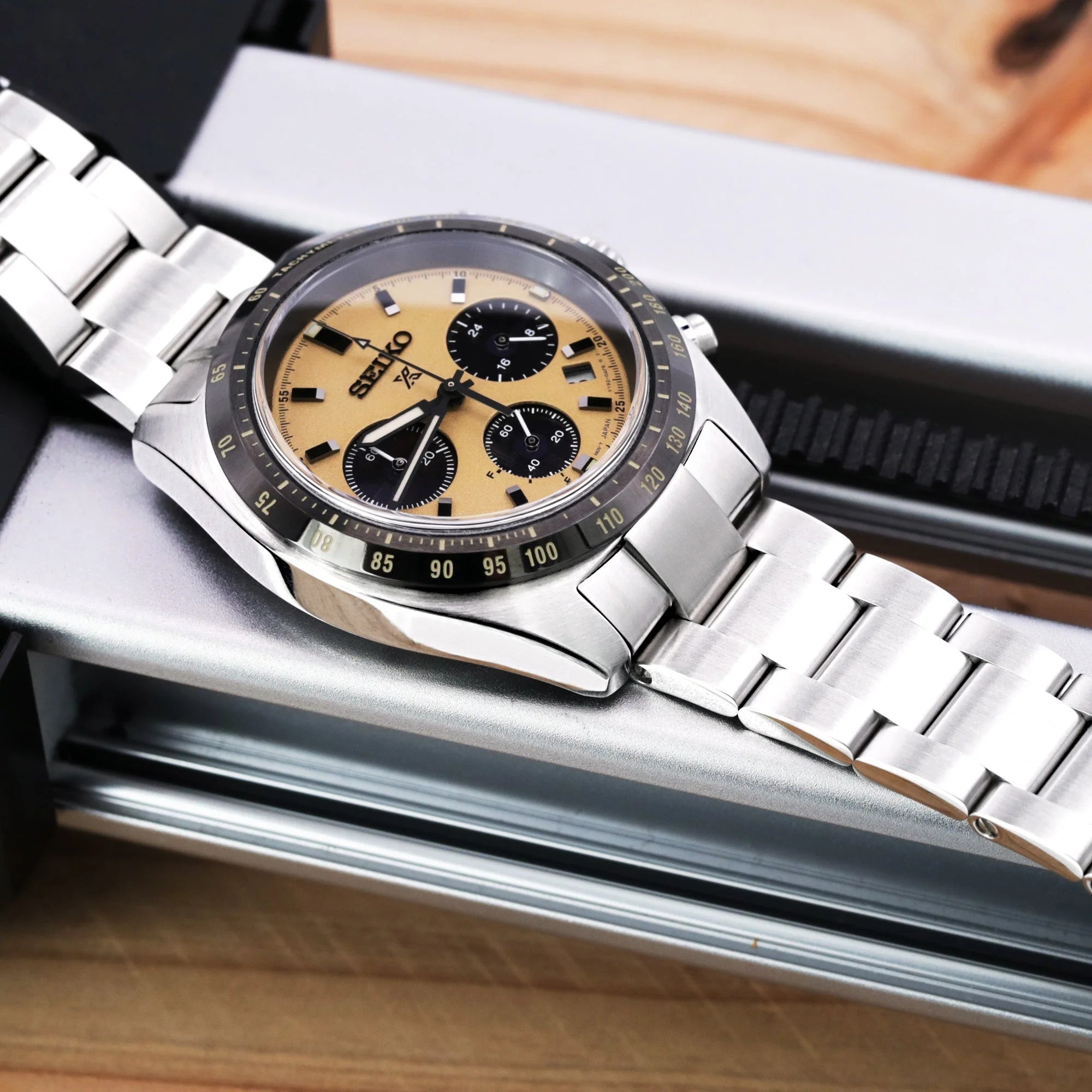 Seiko Speedtimer chronograph watch with champagne dial and stainless steel Super-O Boyer bracelet on wooden desk