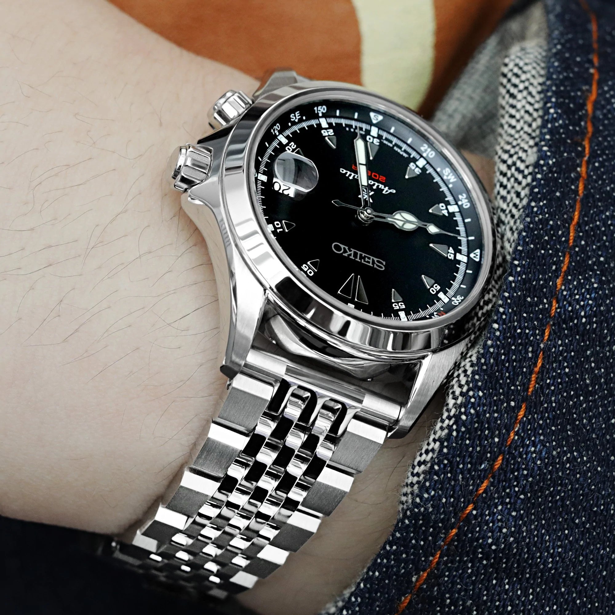 Strapcode stainless steel quick release asteroid bracelet with v-clasp on wrist wearing casual denim and tan shirt