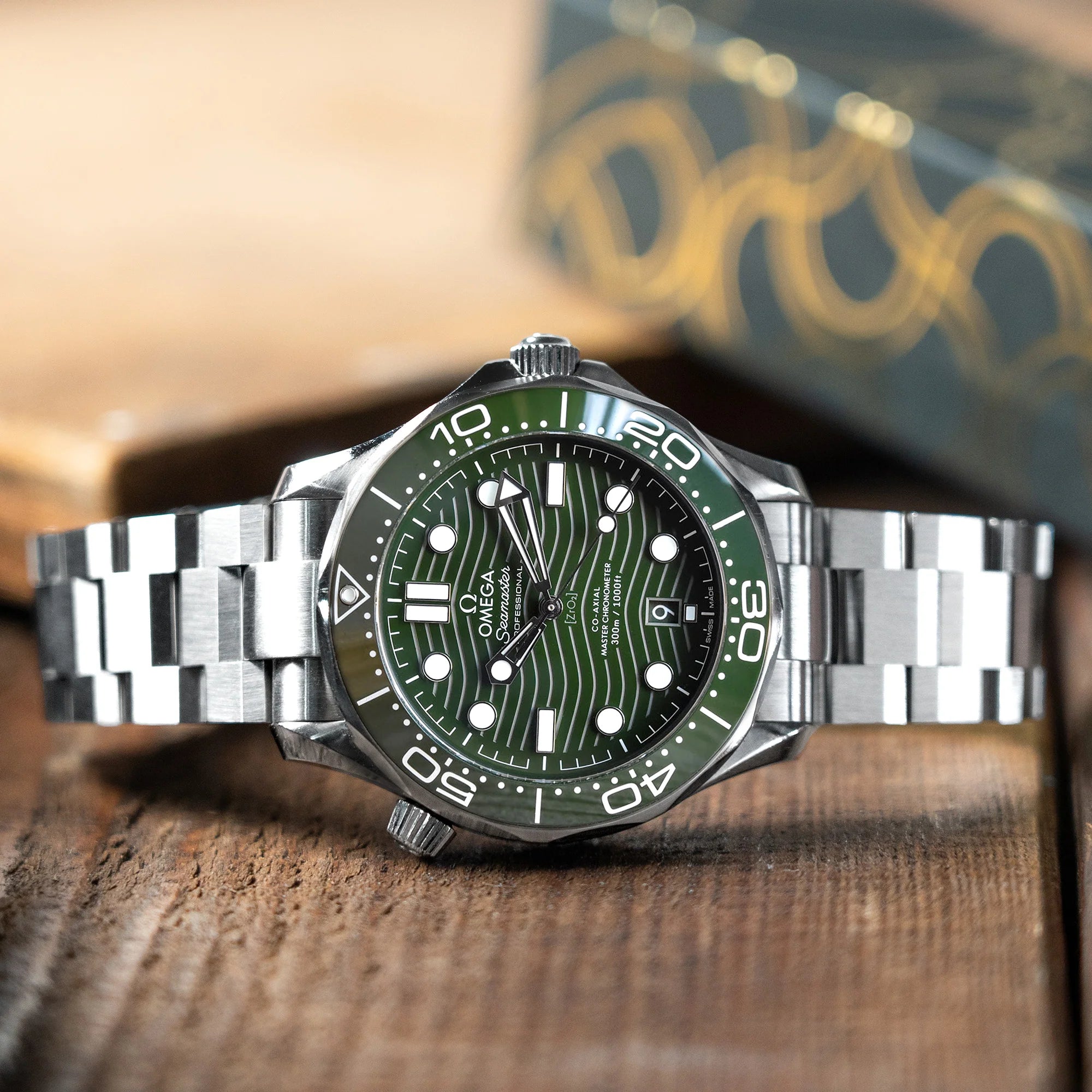 Strapcode Hexad III metal bracelet on Omega Seamaster 42mm watch with green dial and steel case