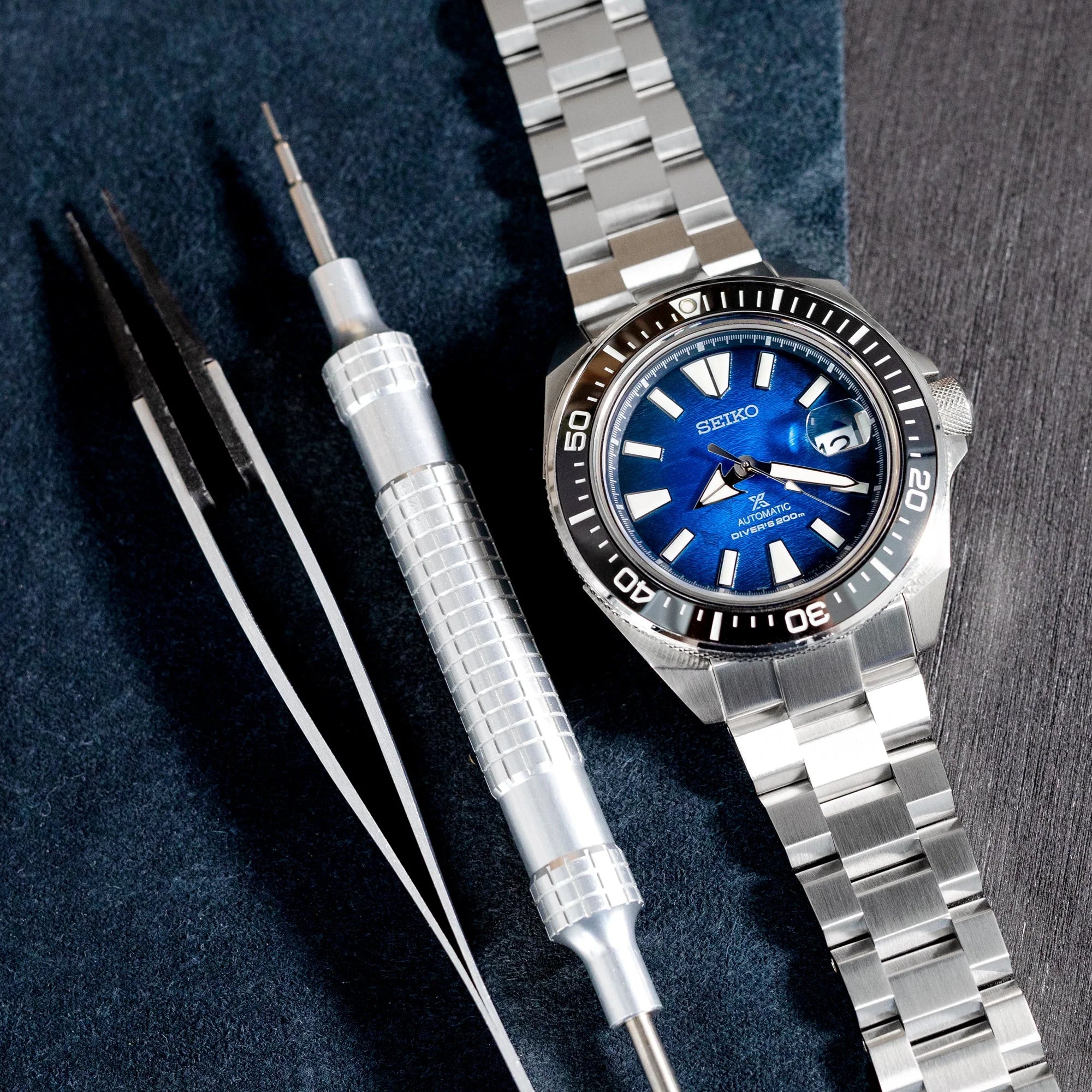 Seiko King Samurai dive watch with blue dial and stainless steel Hexad bracelet, displayed with watch tools