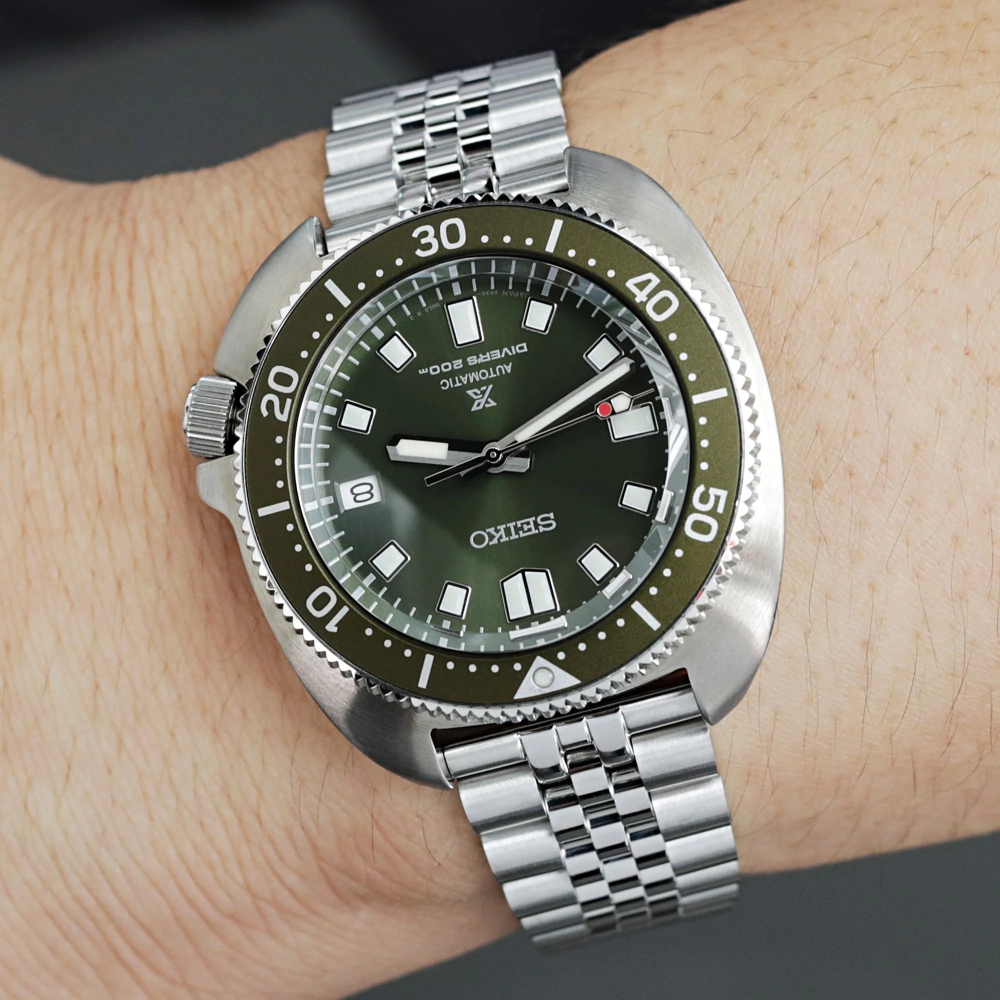 Strapcode Super-Jub II steel bracelet with V-clasp on vintage dive watch with olive green dial and rotating bezel