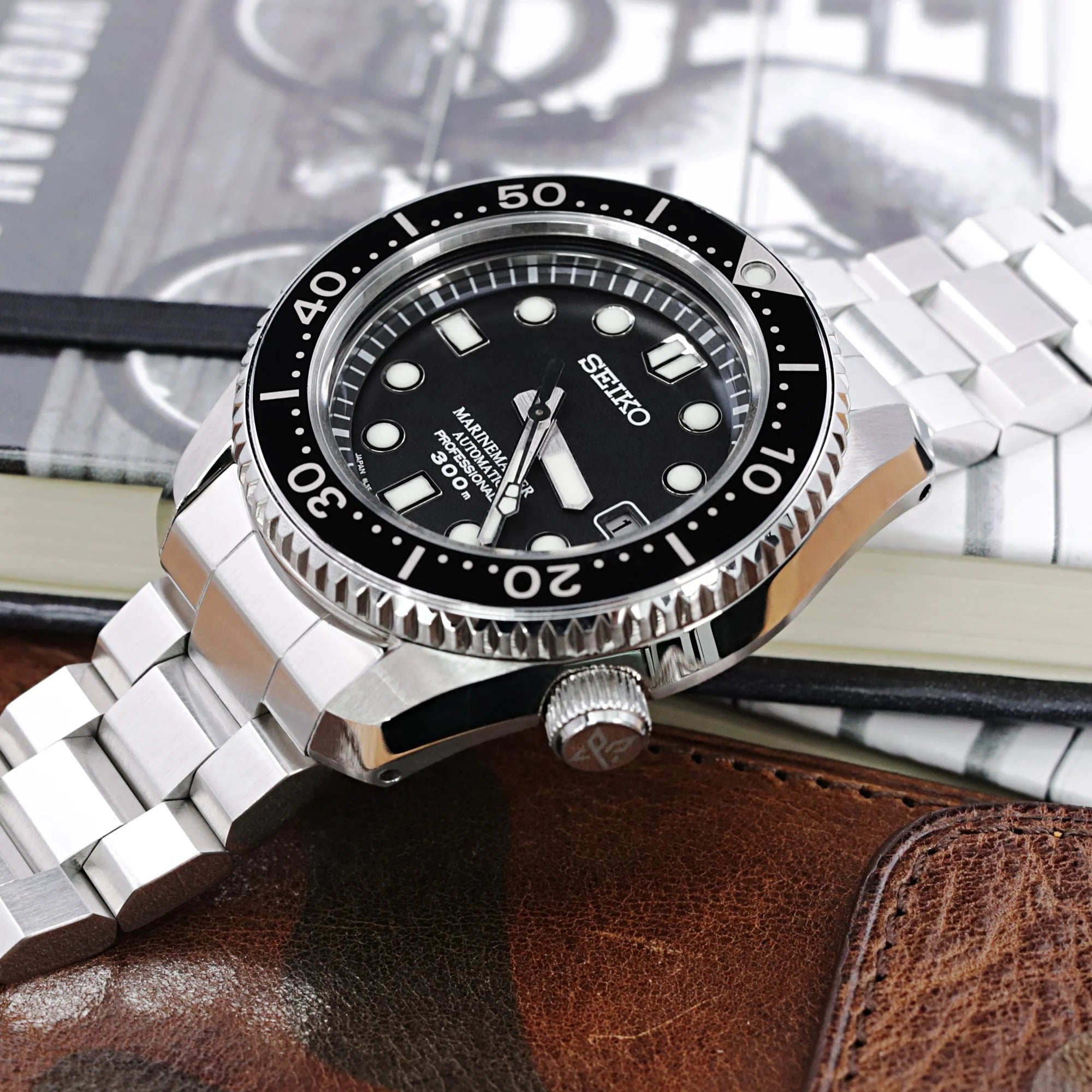 Seiko MarineMaster MM300 SDBX001 dive watch with stainless steel Hexad bracelet on brown leather background