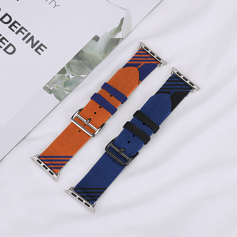 Two woven Apple Watch bands with metal connectors, one orange and navy striped, one blue and black striped, displayed on white background