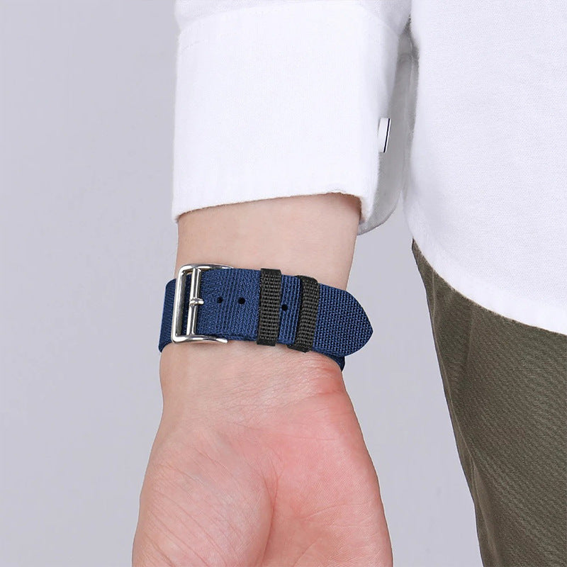 Blue and black nylon Apple Watch band with silver buckle, single tour style on wrist