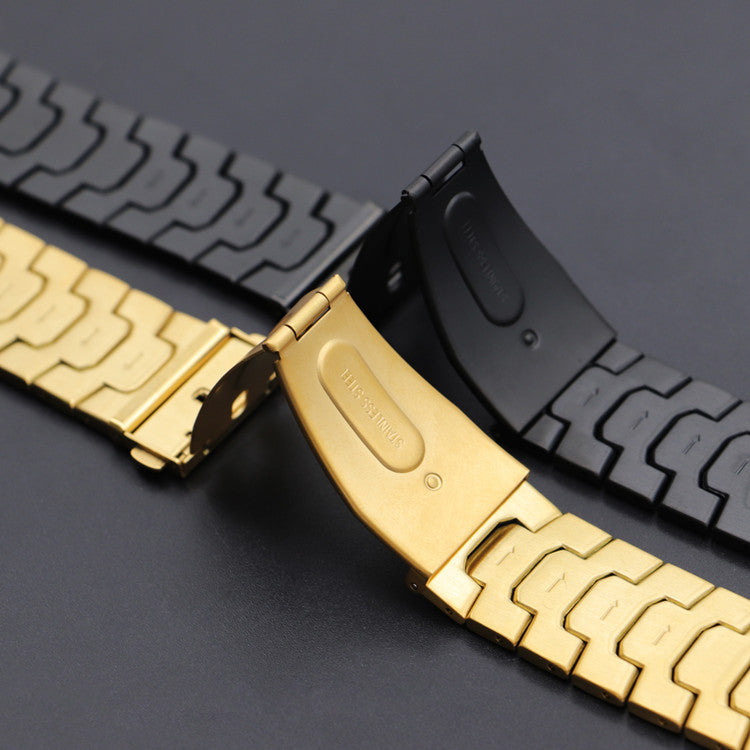 Gold and black stainless steel smartwatch bands with fitted bracelet design, shown in rows on gray surface
