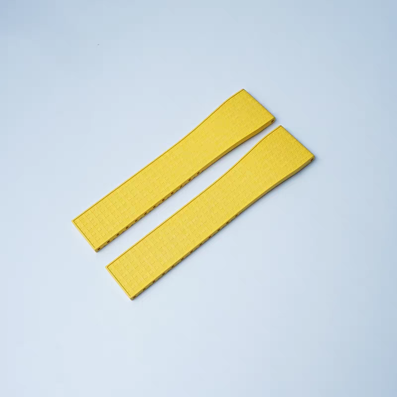 Pair of yellow quick release watch straps with leaf-spring deployant clasp and mosaic FKM rubber texture on blue background