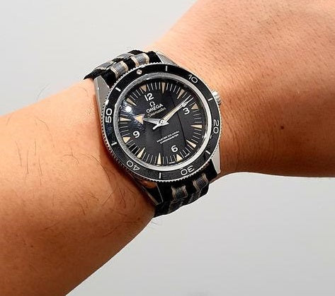 Black sports watch with rotating bezel on wrist, featuring white dial markers and quick release band system