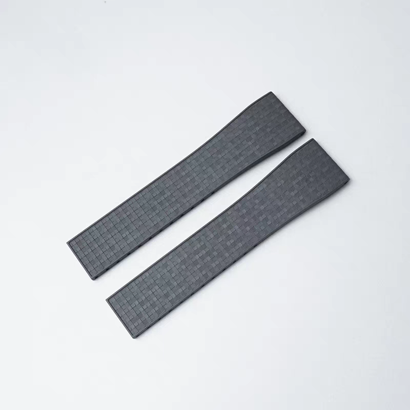 Two dark gray rubber watch straps with textured mosaic pattern and quick release 16mm connectors on white background