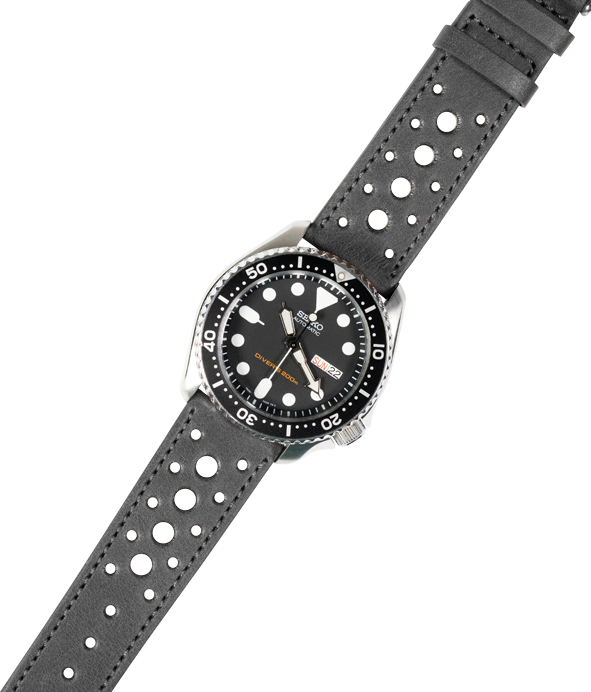 Black leather quick release watch strap with perforated design and silver stainless steel dive watch featuring black dial