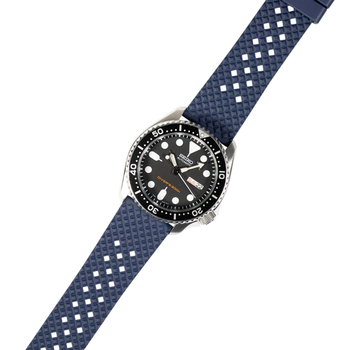 Dive watch with black dial and stainless steel case on navy blue honeycomb quick release rubber strap with white diamond pattern