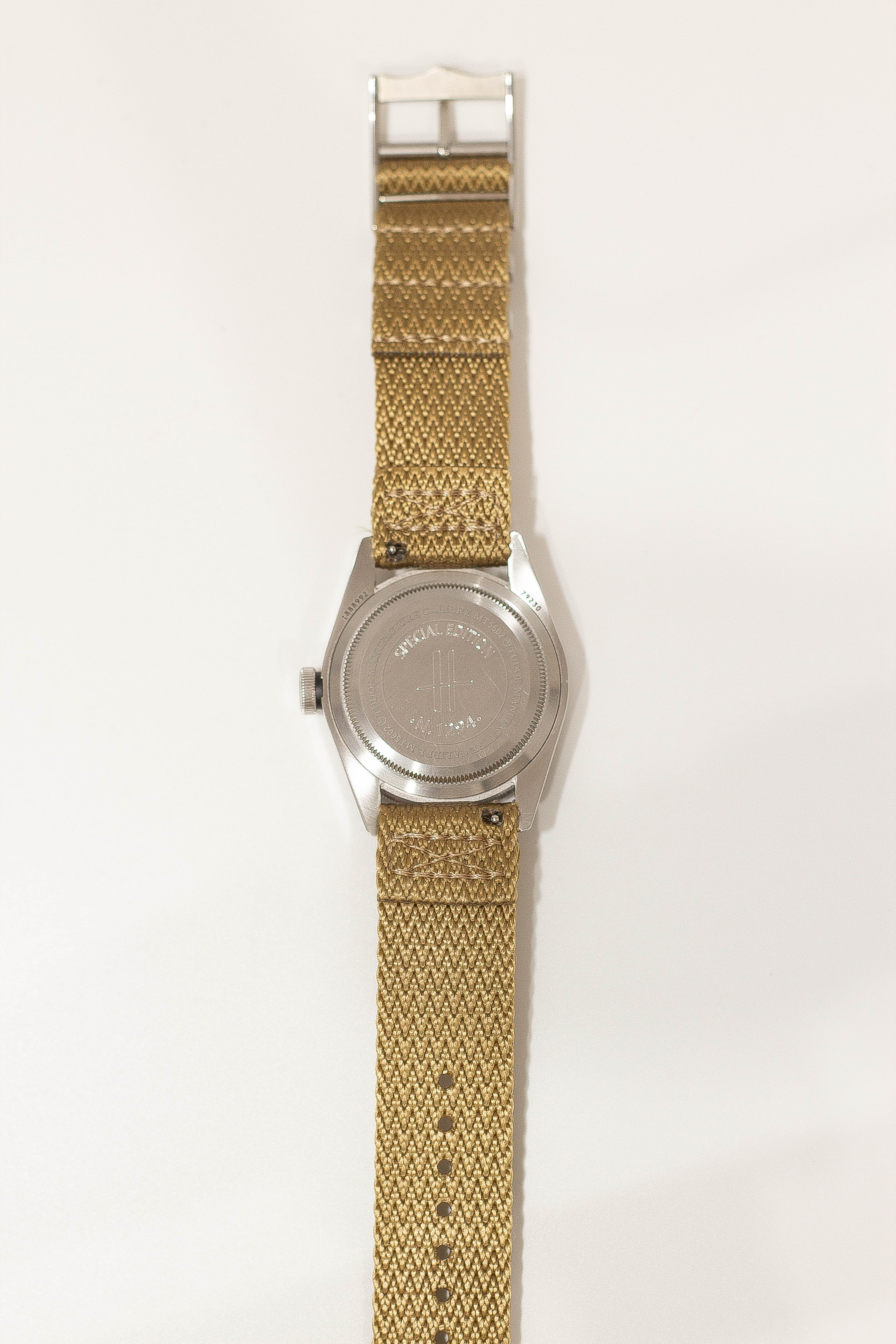 Vintage military field watch with stainless steel case, wheat Militex fabric strap, and quick release buckle