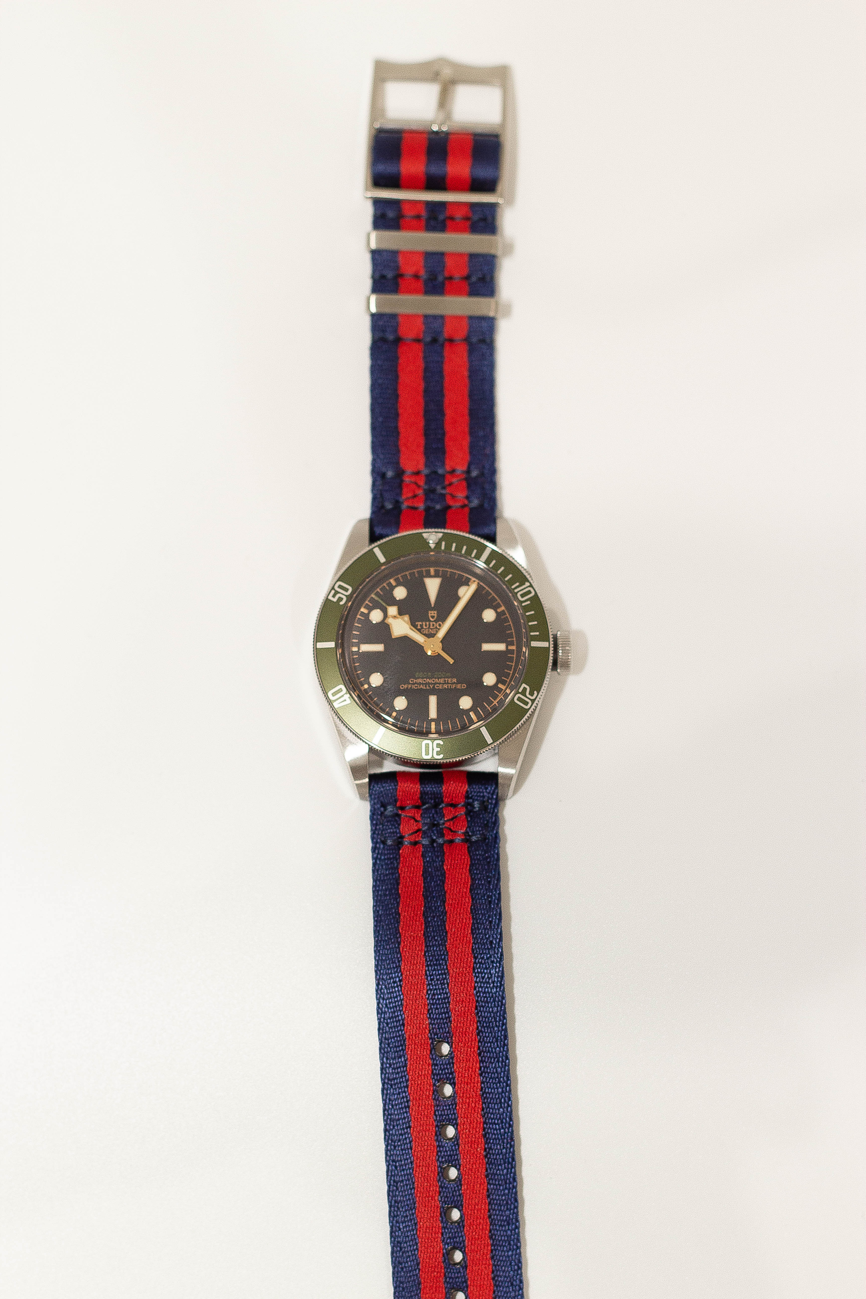 Steel dive watch with navy blue red striped fabric quick release strap