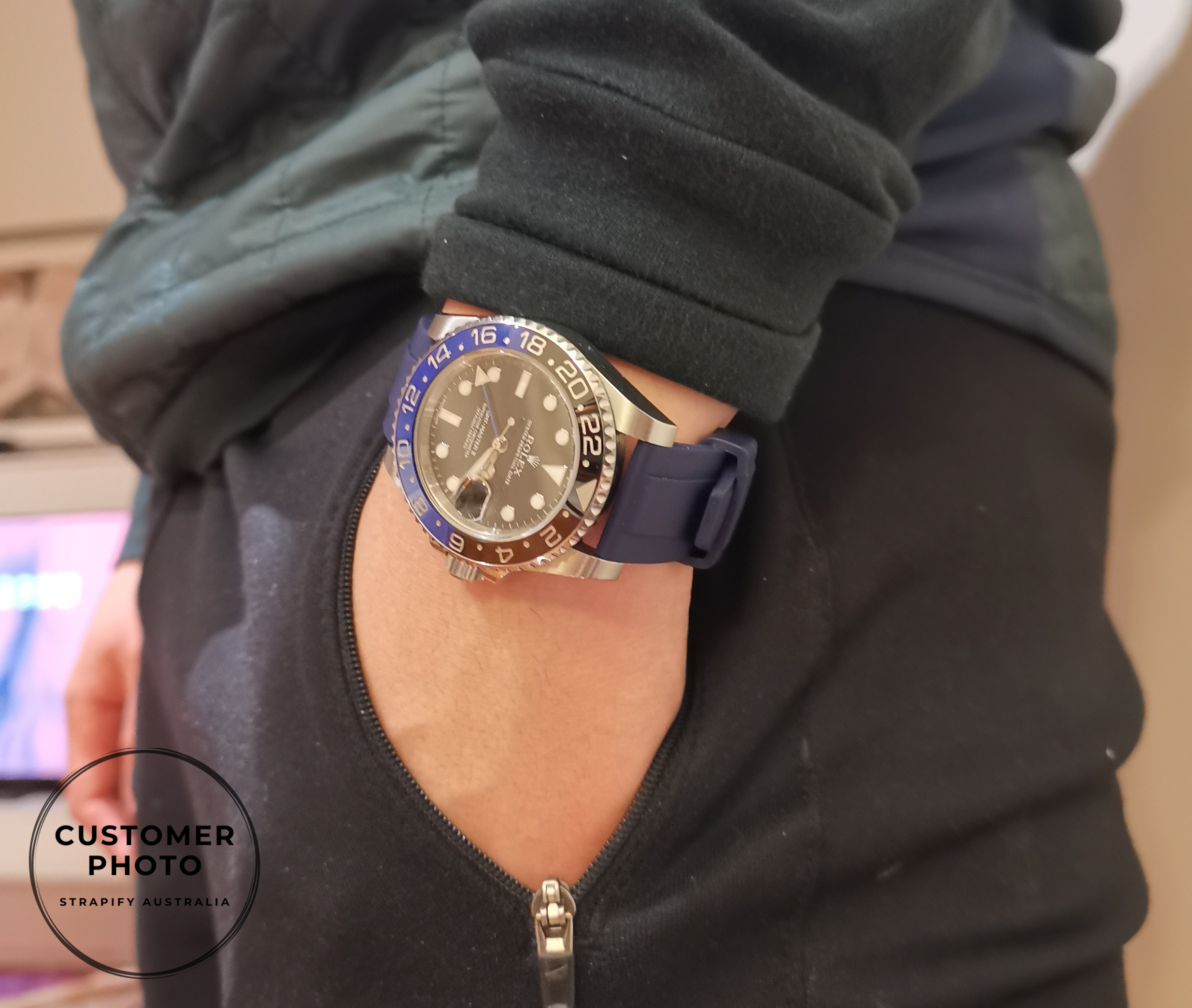 Luxury sports watch with midnight blue FKM rubber quick release strap on wrist, worn with black hoodie