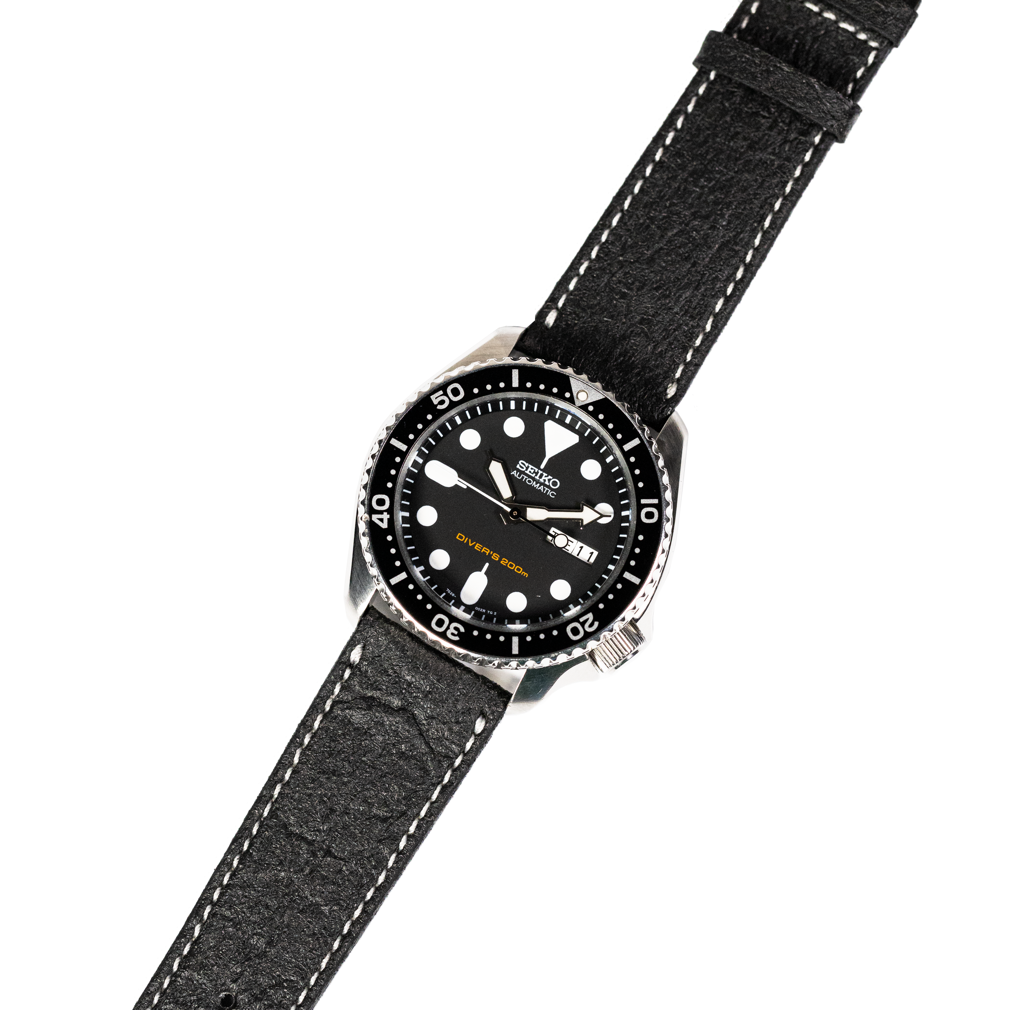 Seiko automatic dive watch with black dial, rotating bezel, and black vegan leather strap with white stitching