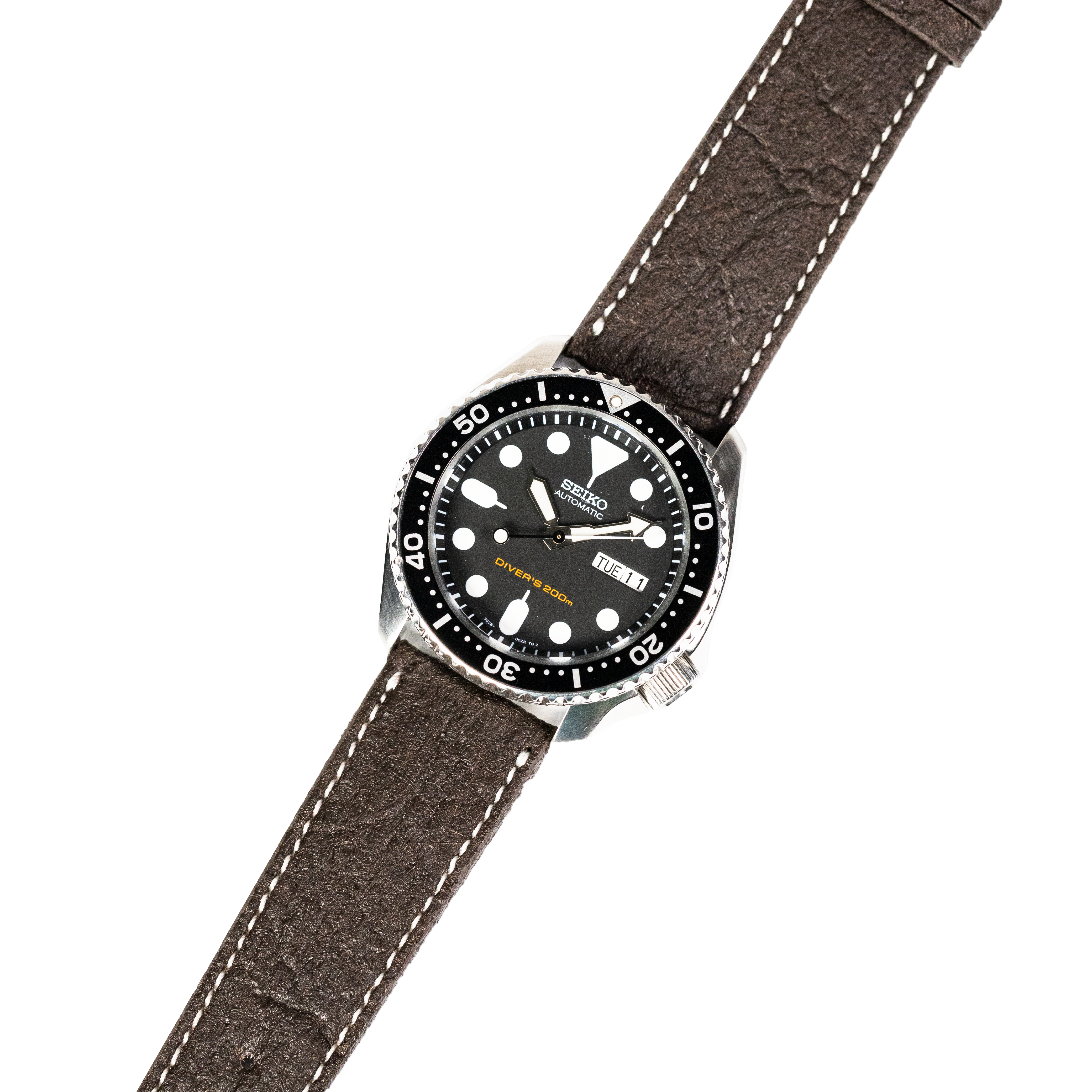 Seiko automatic dive watch with black dial on dark brown vegan leather strap with white stitching