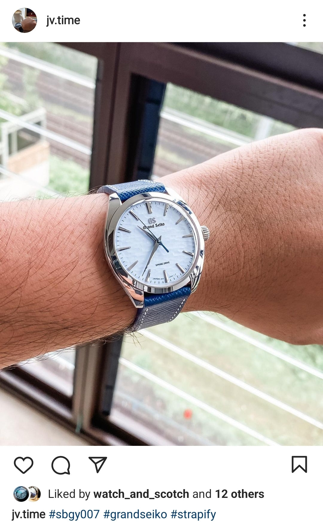 Grand Seiko watch with white dial and blue leather quick-release strap worn on wrist